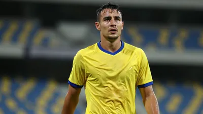 Mid-30s Cape Town City FC midfielder, athletic build, waist-up, drenched in sweat, eyes focused, wearing a plain yellow...